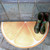 Orange Slice Floor Mat Carole Shiber Designs, half-circle floor mat designed to resemble an orange slice with vibrant orange and yellow hues.