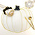 The Blonde Pumpkin, white pumpkin-shaped table topper with gold trim and black accented stem, designed by Carole Shiber Designs, on a white table with gold cutlery and a dotted glass, perfect for fall or Halloween decor.