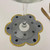 Polka-Dotl Ring-to-Coaster, Black Dots on Grey Carole Shiber Designs coaster with a flower shape, gold trim, and black polka dots under a wine glass.