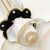 Polka-Dot Napkin Ring, White Dots on Black Ring by Carole Shiber Designs, featuring a black fabric ring with white polka dots and gold trim, with a white fabric napkin.