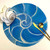Nautilus Round, Blue Carole Shiber Designs, a circular blue decorative plate featuring a snail shell pattern with white accents, accompanied by gold-toned spoon and fork, and a white fabric flower with beige trim.