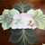 LeafScape with Bunny, decorative leaf-shaped placemat featuring a bunny illustration, colorful eggs, and silver cutlery on a wooden table.