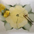 Double Leaf Setting/Centerpiece, decorative tableware with a cracked yellow leaf-shaped plate, accompanied by a gold and wooden spoon and fork, and a yellow floral embellishment. Double Leaf Setting/Centerpiece, decorative tableware with a cracked yellow leaf-shaped plate, accompanied by a gold and wooden spoon and fork, and a yellow floral embellishment.