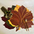 Classic Maple Leaf Collection, Thanksgiving themed table setting with large colorful maple leaf placemats, gold cutlery, and decorative bow, designed by Carole Shiber.