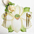 Add a Magnolia Placemat Carole Shiber Designs, a decorative fabric placemat with a large magnolia flower design in soft cream, green, and pink tones with golden utensils placed on it.