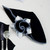 7 Point Leaf - Black/White Carole Shiber Designs, artistic napkin with black and white leaf pattern folded into a unique shape, on a table setting with cutlery.
