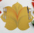 7 Point Leaf, Gold/Copper & Bronze Carole Shiber Designs table placemat with utensils on a white table. 7 Point Leaf, Gold/Copper & Bronze Carole Shiber Designs table placemat with utensils on a white table.