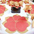 7 Point Leaf - Gold/Copper & Bronze Carole Shiber Designs table centerpiece with gold and copper-colored leaves and roses on a white tablecloth.