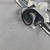 Add a Silver (Grey) Napkins with Black Trim Napkin Carole Shiber Designs, elegant grey napkins with black trim and a decorative flower on a table.