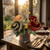 Carole Shiber's Gratitude Napkin Bouquet-in-Vase is a functional and decorative bouquet of rolled-up burnt orange, burgundy, olive, and gold napkins, hand-arranged with leafy Botanic Napkin Rings in a clear vase.