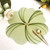 Buttercup Placemat - Mint by Carole Shiber Designs, flower-shaped mint green placemat with layered petal detailing and gold center, styled with gold cutlery and a rolled napkin.