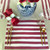 Red & White Striped Placemat Carole Shiber Designs on a dining table set with gold utensils, glassware, a floral centerpiece in a blue and white vase, and a decorative napkin with a flower design.
