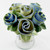The Nantucket Blue Napkin Bouquet Carole Shiber Designs, fabric napkin flowers arranged in a bouquet with green fabric leaves in a clear glass vase.
