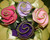 Carole's Party Picks by Carole Shiber Designs, decorative fabric roses in pink, purple, and violet with gold trim arranged on green satin leaves.