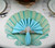 Scallop Shell in Seafoam/Aqua Carole Shiber Designs, decorative shell-shaped paper napkin holder on a table setting.
