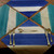 Squares 'n Stripes Set of 4 Carole Shiber Designs, colorful napkin set featuring square and stripe patterns in shades of blue, teal, white, and cream, laid out on a wooden table with silver vintage cutlery.
