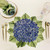Carole Shiber Hydrangea Pacemat, elegant floral placemat with purple hydrangea design and green leaves, perfect for stylish table settings.