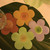 Flower Coasters, Mixed Set of 4 Carole Shiber Designs, colorful flower-shaped coasters on a surface with a wine glass.