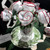 White Peppermint Bouquet Carole Shiber Designs, decorative artificial white peppermint candies arranged in a bouquet with green leaves in a clear glass vase on a festive plate.