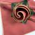 Burnt Orange with Gold Trim Napkin, decorative napkin with a floral design featuring a rolled and layered burnt orange napkin accented with gold trim, green leaves, and a matching tablecloth.