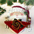 Santa Claus Placemat Carole Shiber Designs, festive Christmas table setting with a Santa-themed placemat, red napkin folded in a rose shape, and glassware.