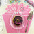Gift Box Party Pink Placemat Carole Shiber Designs, featuring a pink floral design with a cupcake on a clear plate and birthday decorations on a table.