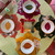 Complete Sweet Leaf Set/4 Carole Shiber Designs, colorful autumn leaf-themed dinnerware with plates, napkins, glasses, and utensils arranged on a table.