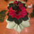 Botanic Holiday Set for 4 Carole Shiber Designs, festive holiday floral arrangement with decorative roses and leaves on a wooden table.