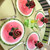 Watermelon Placemat, colorful round placemats designed to resemble a slice of watermelon with a pink interior, black seeds, and a green rind, by Carole Shiber Designs.