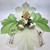 Interlocking Leaf, Pure White/Mint Carole Shiber Designs floral centerpiece with white and mint green leaves and roses, placed on a table setting with utensils.