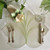 Interlocking Leaf, Pure White/Mint Carole Shiber Designs, elegant table setting with leafy placemats, floral napkin ring, wine glass, and cutlery.