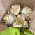 Ivory/Gold Bouquet Carole Shiber Designs, elegant fabric roses with gold piping details, arranged on brown tissue paper with a green satin ribbon.