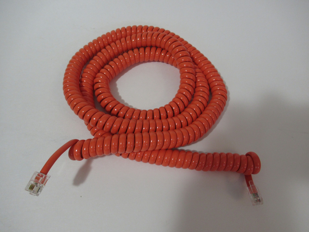 Orange coiled handset cord with modular connectors . Good quality