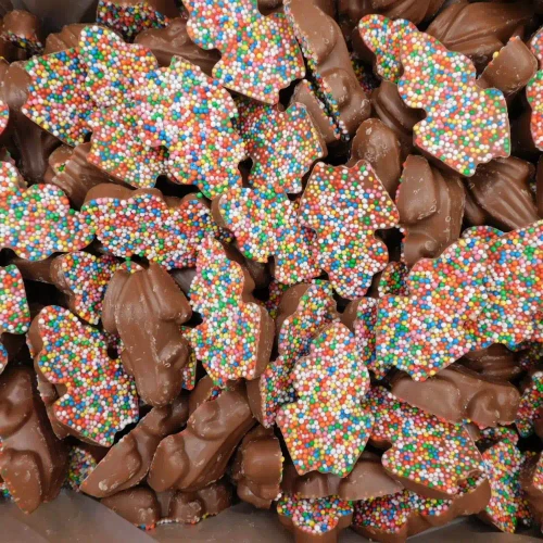 Close-up of milk chocolate frogs with multicolour speckles in 5kg bulk packaging from The Professors Online Lolly Shop