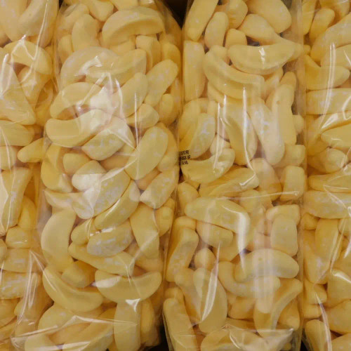 Close-up of Betta Candy Bananas 4kg box with yellow banana-shaped lollies, available at The Professors Online Lolly Shop.