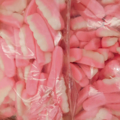 Close-up of Allseps Bulk False Teeth in pink and white, showcasing soft, mint-flavoured novelty candy - available at The Professors Close-up of Allseps Bulk False Teeth in pink and white, showcasing soft, mint-flavoured novelty candy - available at The Professors