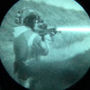 Through the tube night vision view showing a tactical operator aiming with the powerful beam of the DesignateIR-V infrared laser