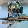 FDE USNV Advanced Mission Ready Kit mounted on a tactical rifle with a night vision helmet setup in the background