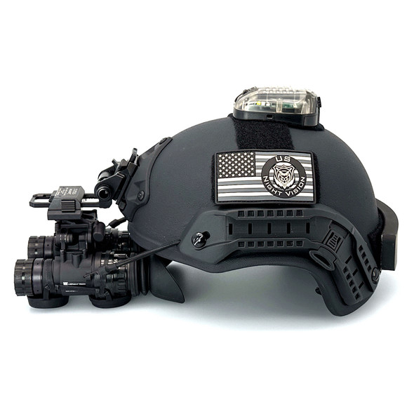 Side profile of a fully equipped black FAST Ballistic Helmet Level IIIA with mounted night vision goggles ear protection and strobe light