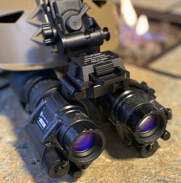 Angled view of a tactical helmet setup featuring two PVS-14 night vision monoculars bridged together using the dual dovetail mount