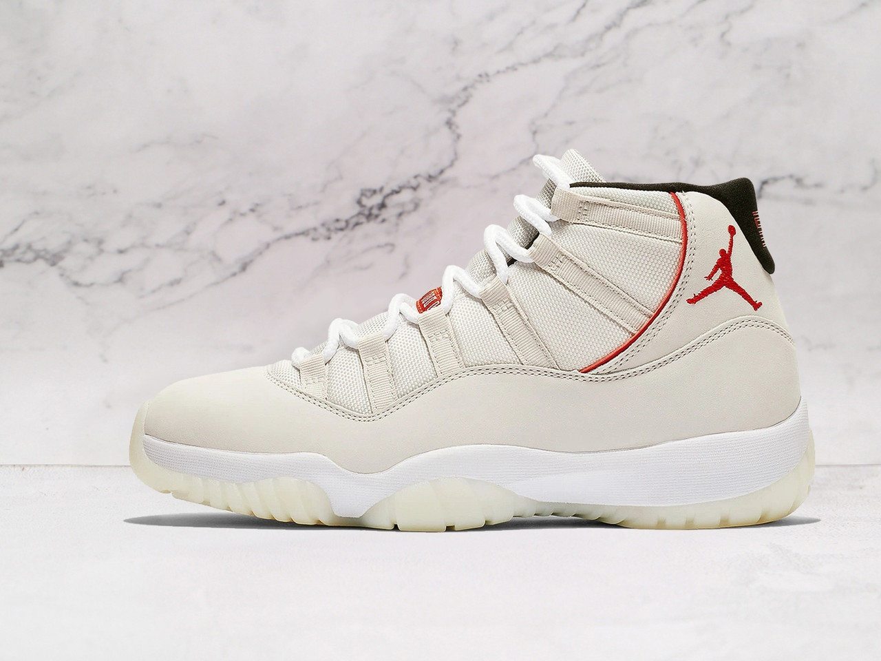 Side view of Air Jordan 11 Retro 'Platinum Tint' with Platinum Tint nubuck upper and University Red Jumpman