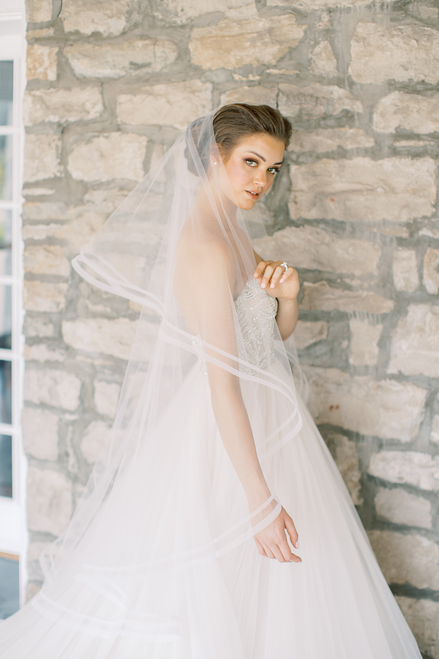 A tiered, waltz length veil, the Tart style is trimmed with a double border of woven horsehair which provides both body and a dramatic aesthetic.