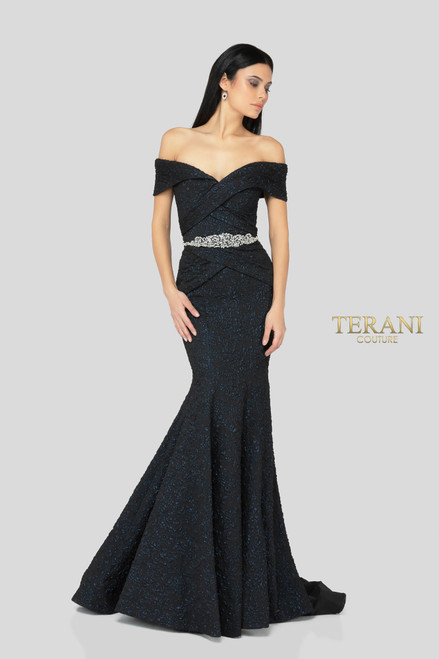 Elegant off the shoulder evening gown in tonal brocade with rose motif. The flattering bodice is features elegant draping and a crystal embellished waistline. The fitted skirt opens up to a beautifully structured mermaid bottom.