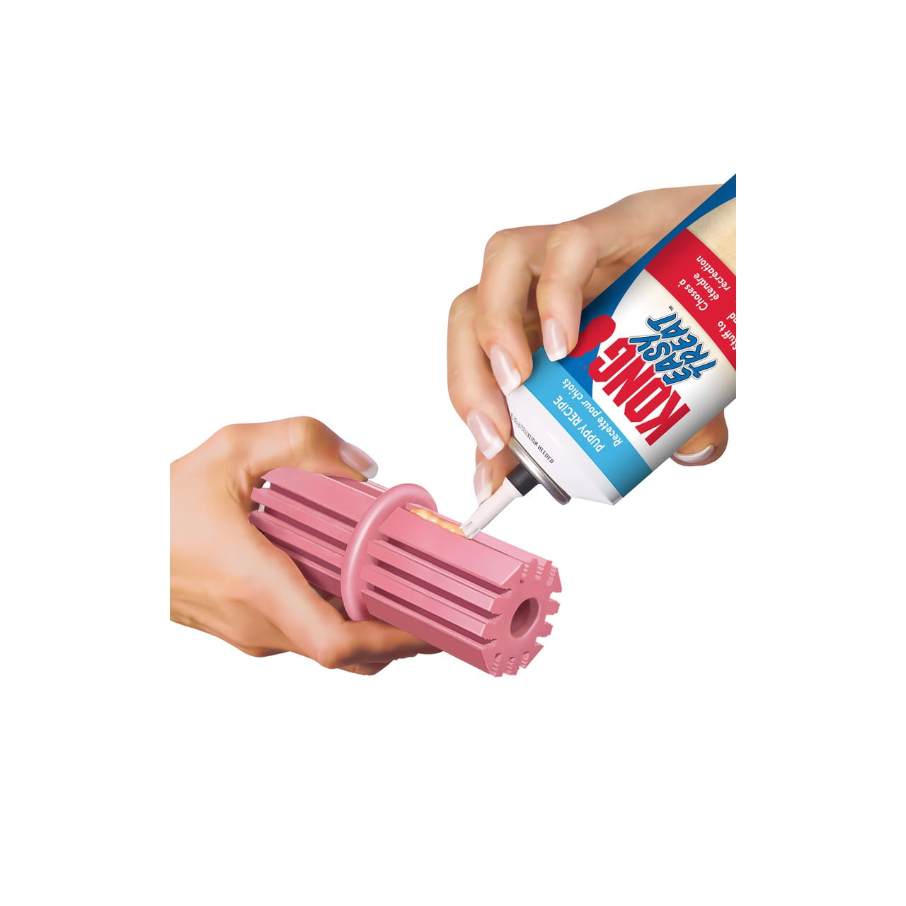 KONG Puppy Teething Stick Large in pink, being filled with KONG dog treat paste.