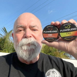 Customer holding two FlowBlend CBD pouch cans, Cinnamon Haze and Dewdrop Apple, outside on a sunny day
