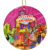 Las Vegas Round Ornament 3-D carved and covered with epoxy, pink background and colorful icons of Vegas. 
