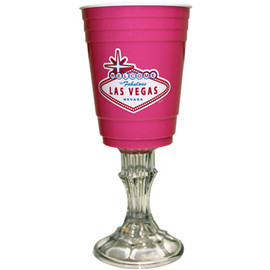 Pink solo cup style, hard plastic cup, on top of a candlestick. Made to resemble a wine glass..
