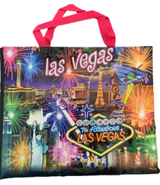 Pink handled, black background tote bag shows a Las Vegas at the top over the Las Vegas Casinos in bright colors with fireworks bursting overhead.
