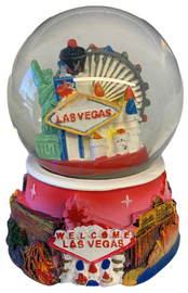 Acrylic base and a Glass Snowglobe. Base is Pink with colorful icons. Inside the snowglobe has glitter snow and colorful 3D versions of the Las Vegas Casinos that you know and love.