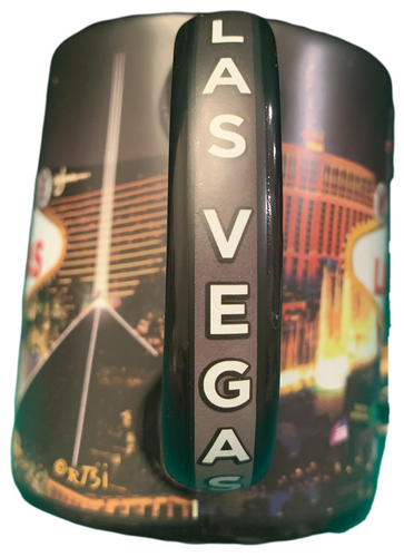 Oversized Las Vegas ceramic coffee mug with a Las Vegas Sign and city Scene design shown on a black mug, handle view.